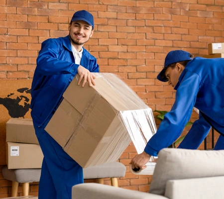 Reliable moving crew lifting and carrying wrapped furniture during a home move by City of Angels Move